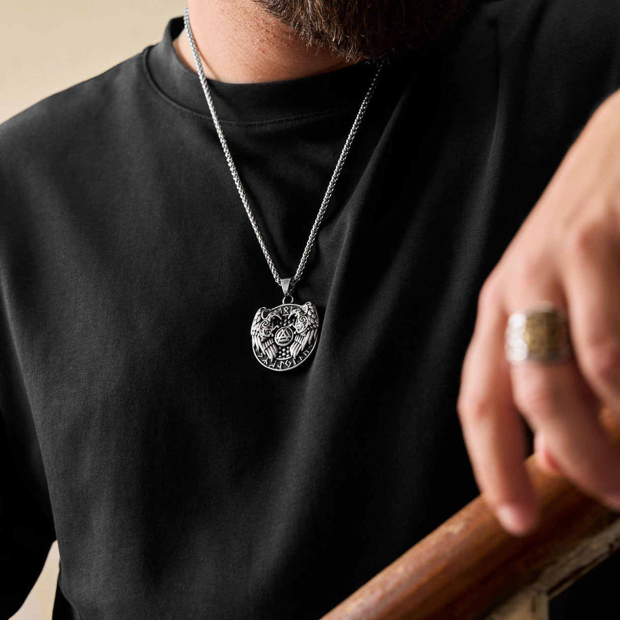 Hugin & Munin pendant with Odin’s ravens and Valknut, worn by a bearded man with Viking ring and black shirt.