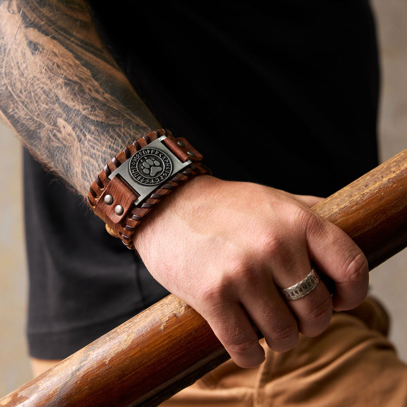 Brown leather Viking bracelet with bear paw symbol worn on wrist – Norse heritage accessory