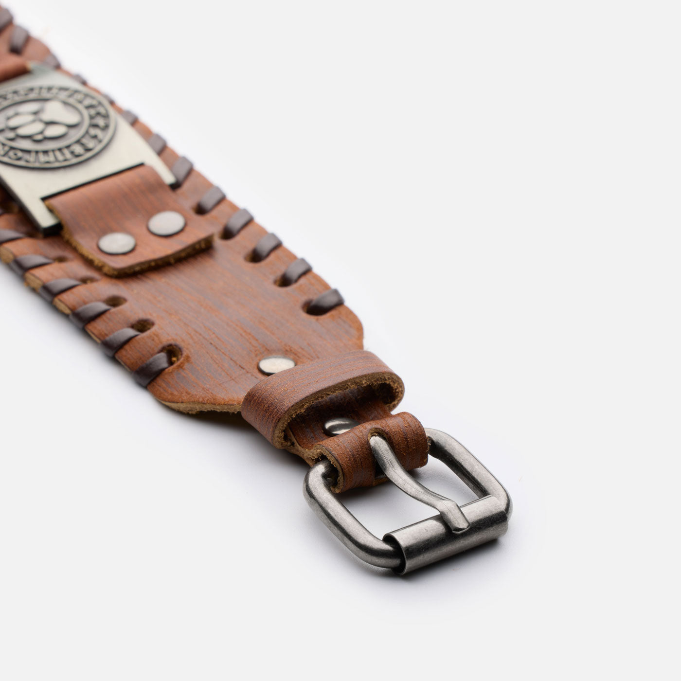 Close-up of antique bronze buckle and brown leather strap with Viking bear paw design
