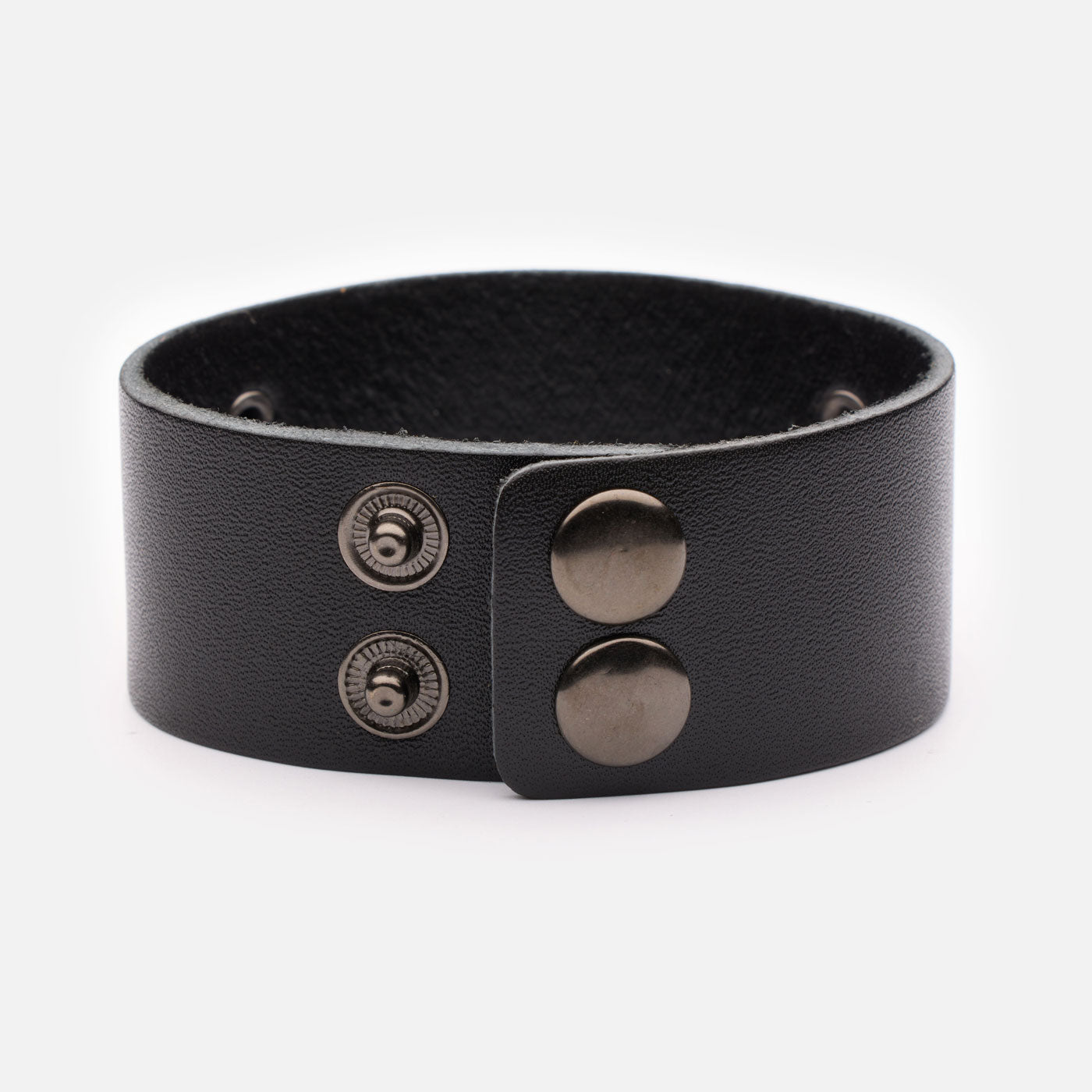 Back view of black leather bracelet showing two metal snap buttons for secure and adjustable fit.
