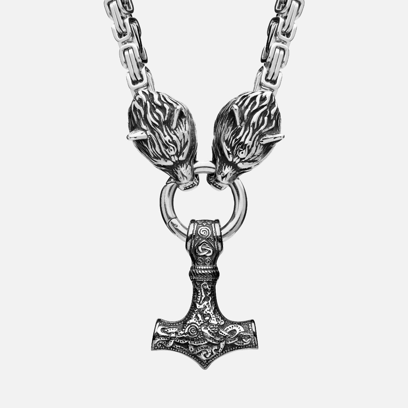 Detailed front view of a Viking necklace featuring Thor's hammer Mjölnir hanging from two wolf heads, attached to a thick king chain.