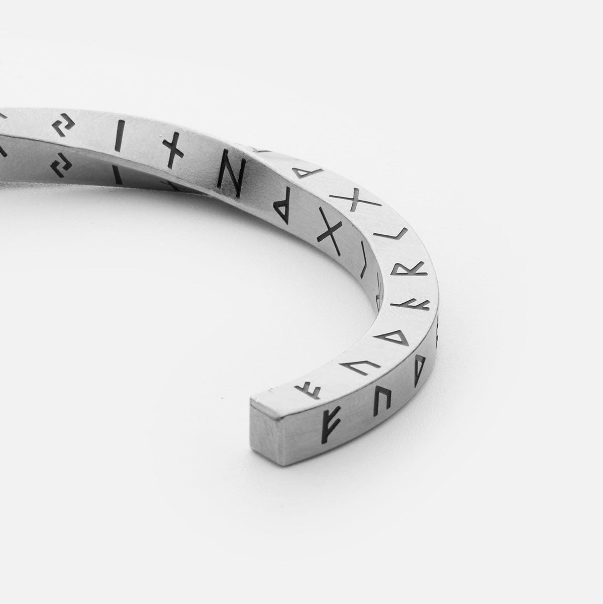 Detailed close-up of the Elder Futhark Rune Bracelet, showcasing the deep-engraved Norse runes on a silver stainless steel Viking cuff, symbolizing ancient wisdom and strength.