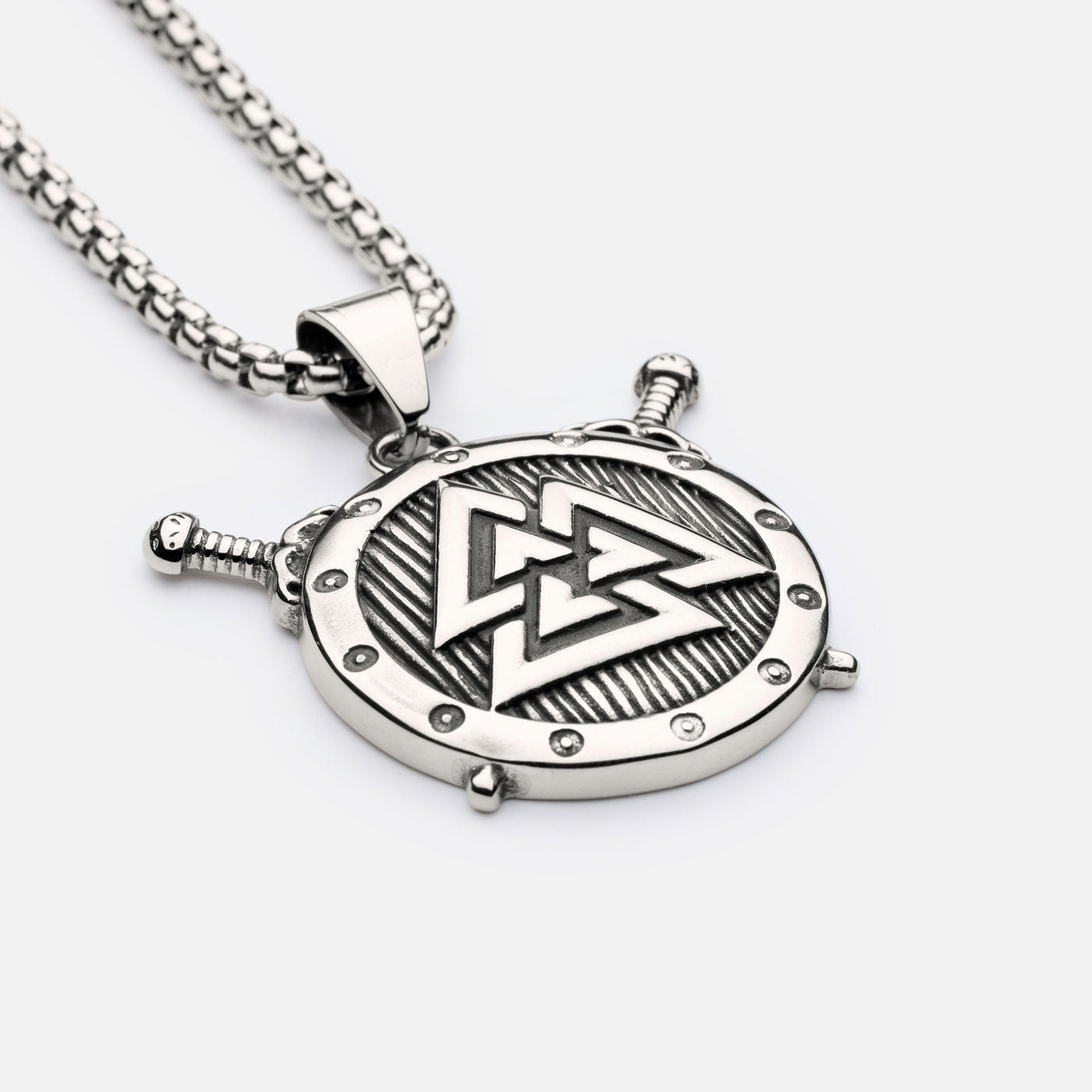 Side view of Valknut shield pendant with raised swords and detailed border, hanging from a robust stainless steel box chain.