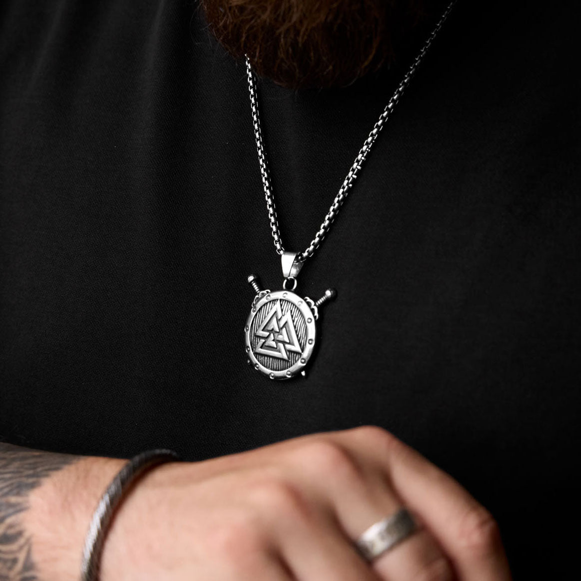 Valknut shield necklace worn on chest, showing Odin's symbol Valknut of the fallen and Viking strength, paired with a bold box chain.