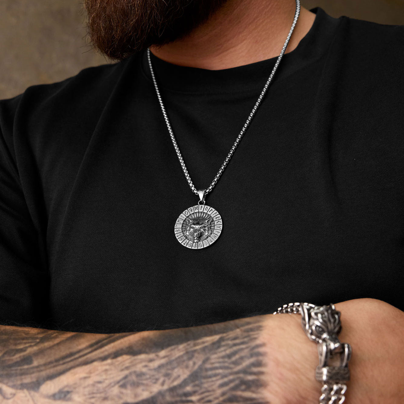 Norse wolf necklace with Elder Futhark runes worn by bearded man, paired with Viking bracelet, showing bold warrior look.