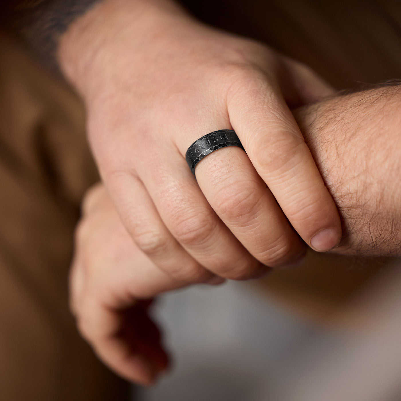 Close-up of a hand wearing the Antique Viking Rune Ring – Aged black stainless steel ring engraved with the full Elder Futhark rune alphabet, embodying Norse heritage and mysticism.