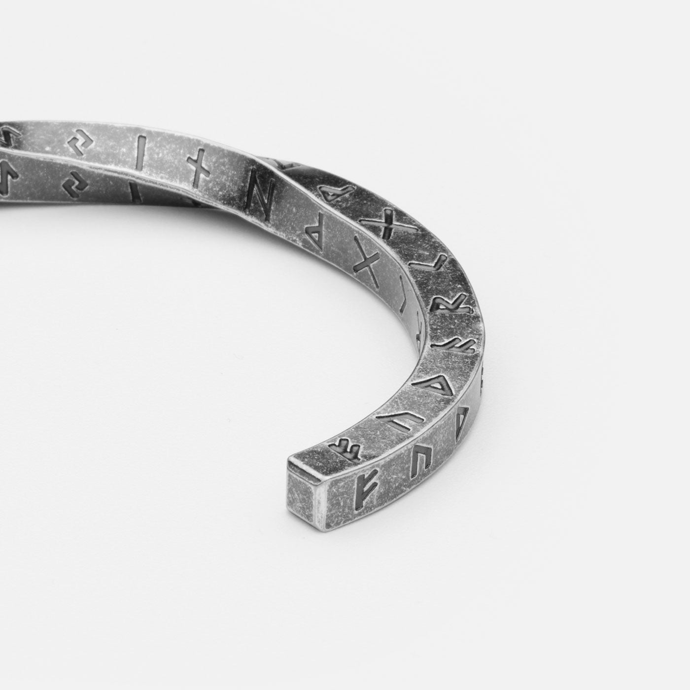 Detailed close-up of the Elder Futhark Rune Bracelet, showcasing the deep-engraved Norse runes on a rugged stainless steel Viking cuff, symbolizing ancient wisdom and strength.