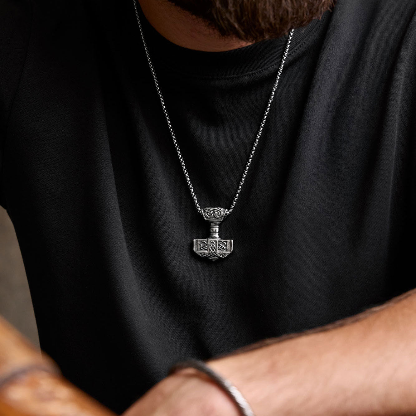 Forged in Midgard Mjölnir necklace worn on chest – medium-sized Thor’s Hammer pendant with box chain styled with black shirt