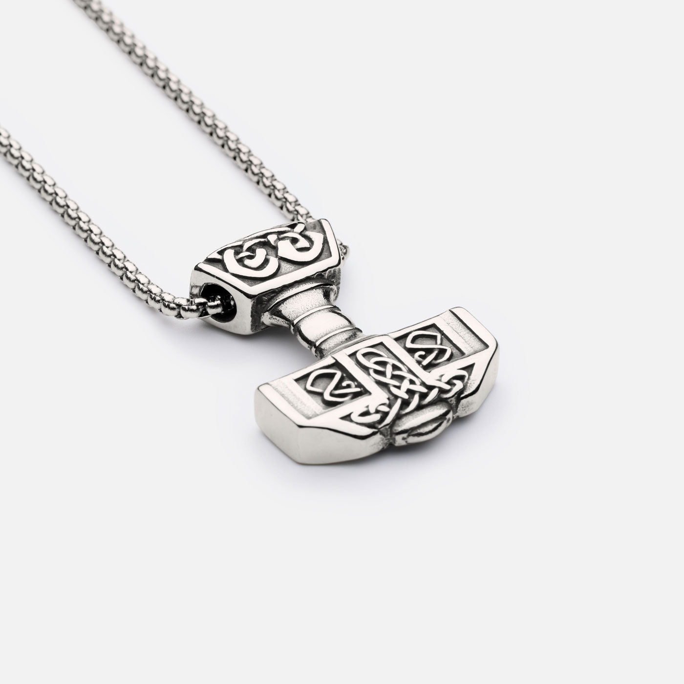 Forged in Midgard Thor’s Hammer necklace – detailed view of the Mjölnir pendant with intricate knotwork, shown with box chain on light background