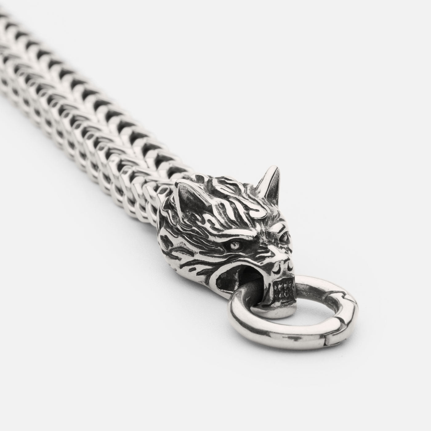 Close-up of the stainless steel Geri and Freki wolf bracelet from Odin Trinkets, showcasing the intricate detailing of the wolf head clasp biting onto a central ring, symbolizing Odin’s loyal companions.