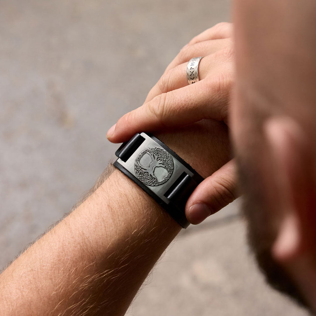 Man wearing black Yggdrasil bracelet with silver-colored plate and Norse tree symbol