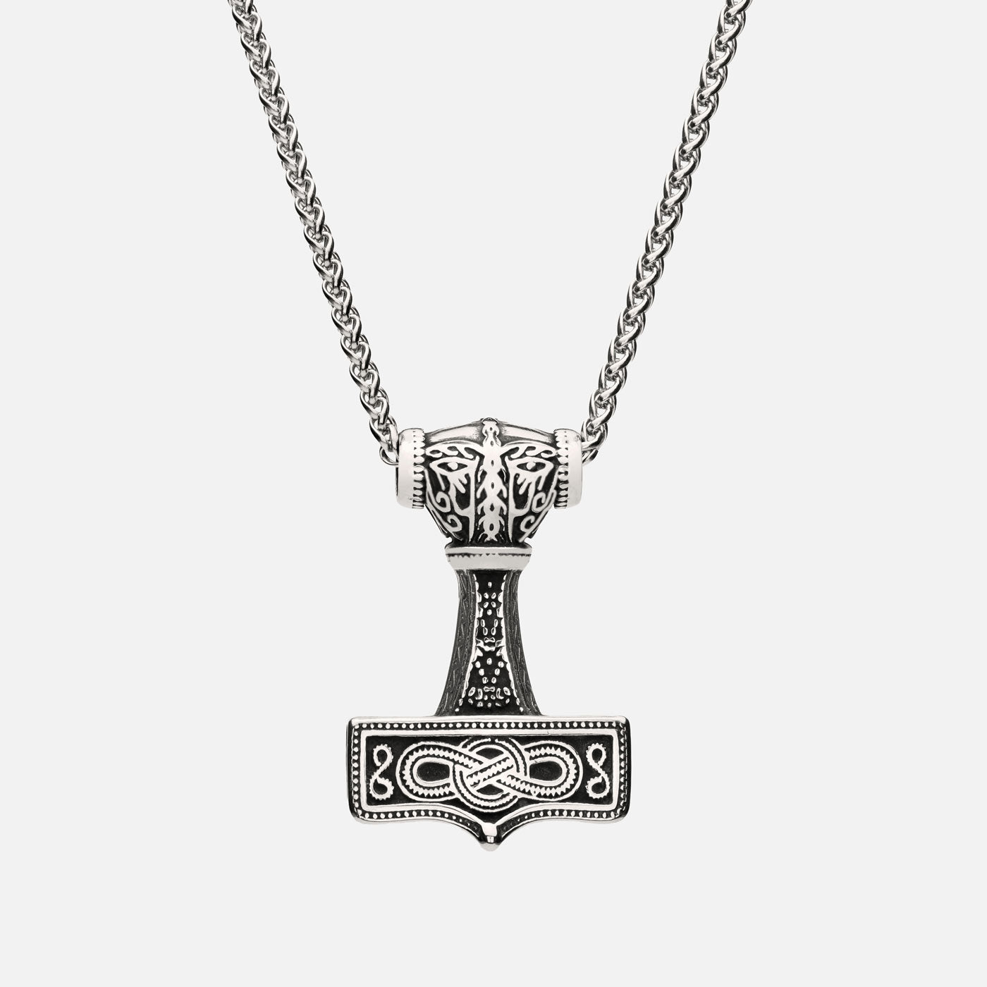 Close-up of the Mjölnir of Asgard pendant showing Norse knotwork in antique silver