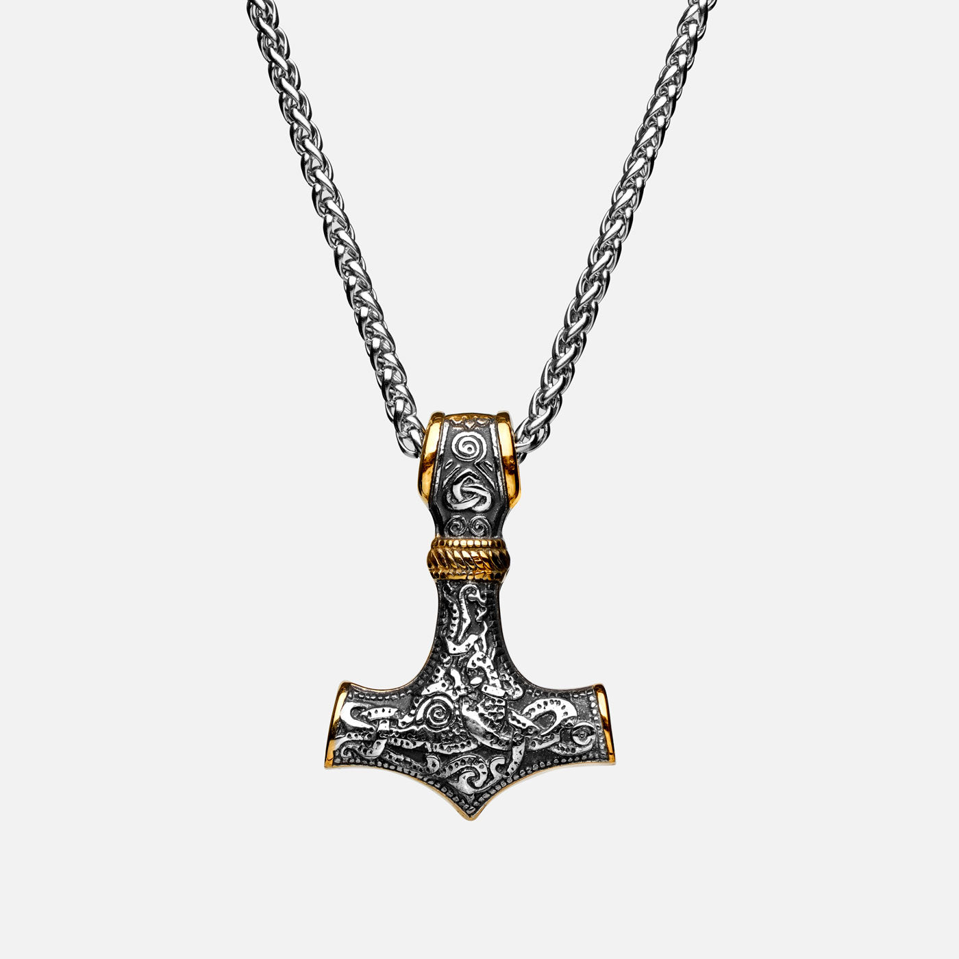 Front view of the stainless steel Mjölnir pendant in gold and silver from Odin Trinkets, featuring intricate Viking engravings and a simple yet bold chain, symbolizing Thor’s legendary hammer.
