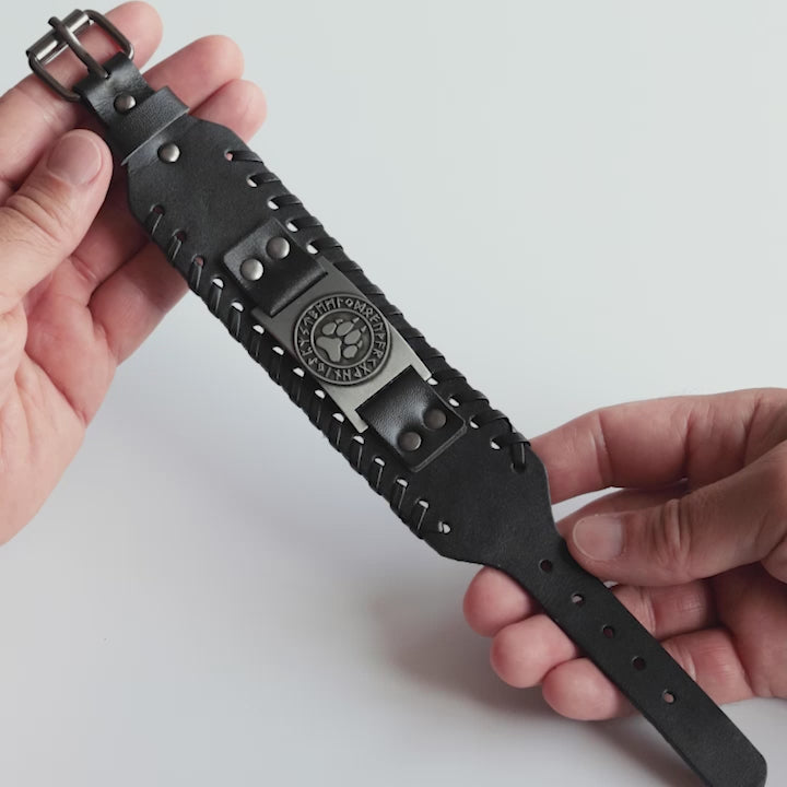 Close-up video of Odin Trinkets close-up video of black leather Viking bracelet featuring wolf paw symbol surrounded by runes, inspired by Norse mythology, with an adjustable buckle closure for men