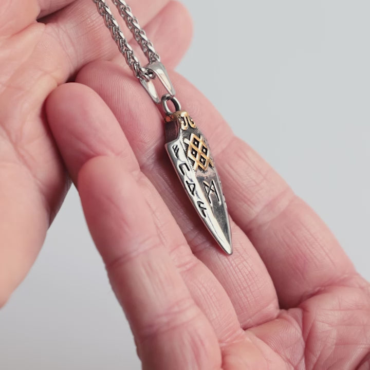 Close-up video of a stainless steel Gungnir necklace, featuring Odin’s legendary spear adorned with gold accents and Elder Futhark runes. A powerful Viking talisman symbolizing precision, strength, and divine wisdom. The video highlights the intricate details and craftsmanship—an iconic piece from Odin Trinkets.