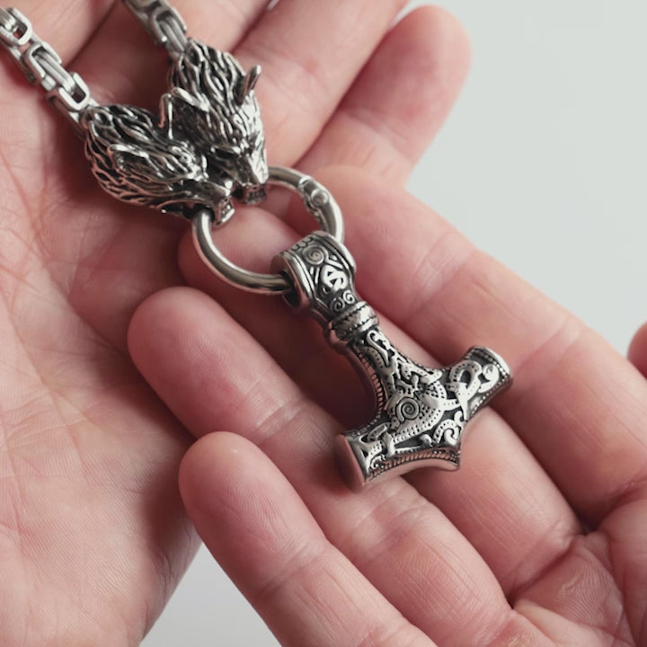 Close-up video of a stainless steel Mjölnir king chain necklace, featuring wolf head clasps and an intricately detailed Thor’s hammer pendant. A timeless Viking symbol of protection, power, and Norse heritage. This bold piece reflects the spirit of the North—designed with precision by Odin Trinkets.