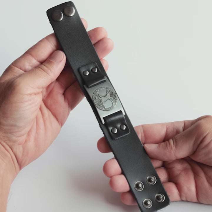 Close-up video of Odin Trinkets close-up video of black leather Viking bracelet featuring the Yggdrasil tree of life symbol, a powerful design from Norse mythology representing strength and connection