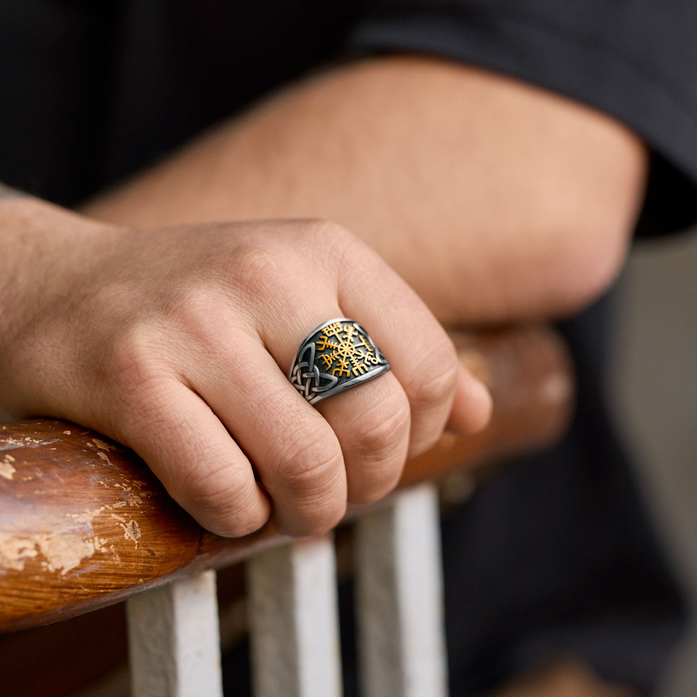 Close-up of the Vegvisir ring worn on a hand, showcasing the golden Vegvisir symbol and detailed Celtic knot pattern on the silver band.