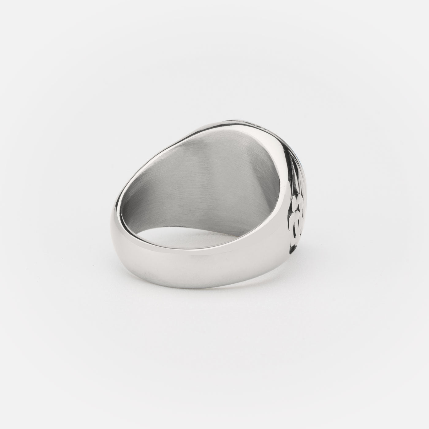 The side view of a stainless steel Yggdrasil ring, highlighting the smooth, polished band and the Celtic knotwork design that curves around the ring's edge.
