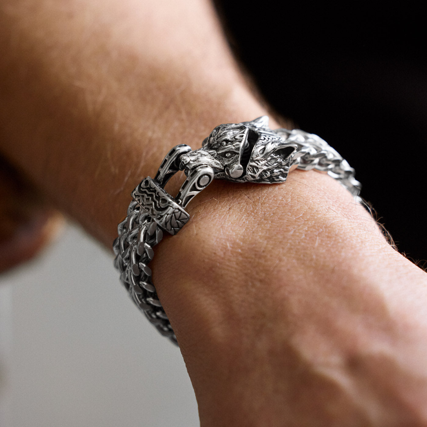 Close-up of the upgraded stainless steel Fenrir wolf bracelet on wrist, featuring a newly designed Norse wolf head clasp and bold Viking chain pattern, from Odin Trinkets.