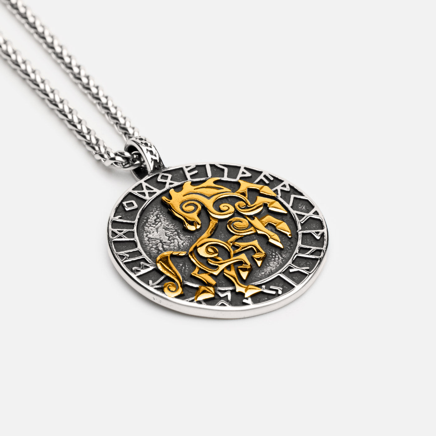 Close-up of a Viking necklace featuring Sleipnir, the eight-legged horse of Odin, in gold on a textured silver medallion, surrounded by the Elder Futhark runes.