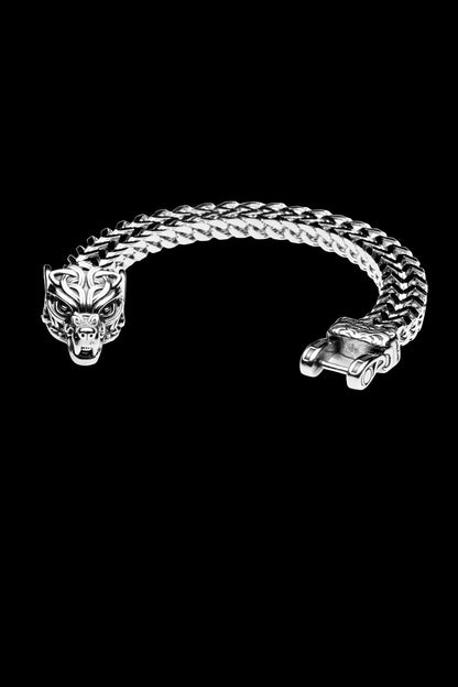 Fenrir bracelet with a silver wolf head clasp, inspired by the legendary wolf Fenrir from Norse mythology, featuring a bold woven chain design and displayed on a transparent background. Available at Odin Trinkets.