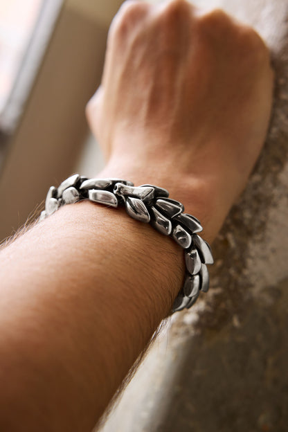 Close-up of the Jormungand bracelet with a serpent-inspired design, worn on a wrist, showcasing its sleek scales and Norse mythology symbolism. Available at Odin Trinkets.