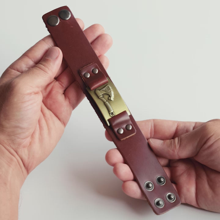 Close-up video of Odin Trinkets Viking bracelet in brown leather with detailed axe symbol, bold Norse mythology inspired jewelry for men
