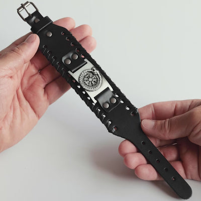 Close-up video of Odin Trinkets close-up video of black leather Viking bracelet featuring the Norse ouroboros Jörmungandr encircling the Vegvisir compass, with an adjustable buckle closure for a bold Viking look