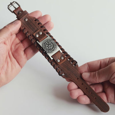 Close-up video of Odin Trinkets close-up video of brown leather Viking bracelet featuring the Vegvisir compass symbol from Norse mythology, highlighted with an adjustable buckle closure