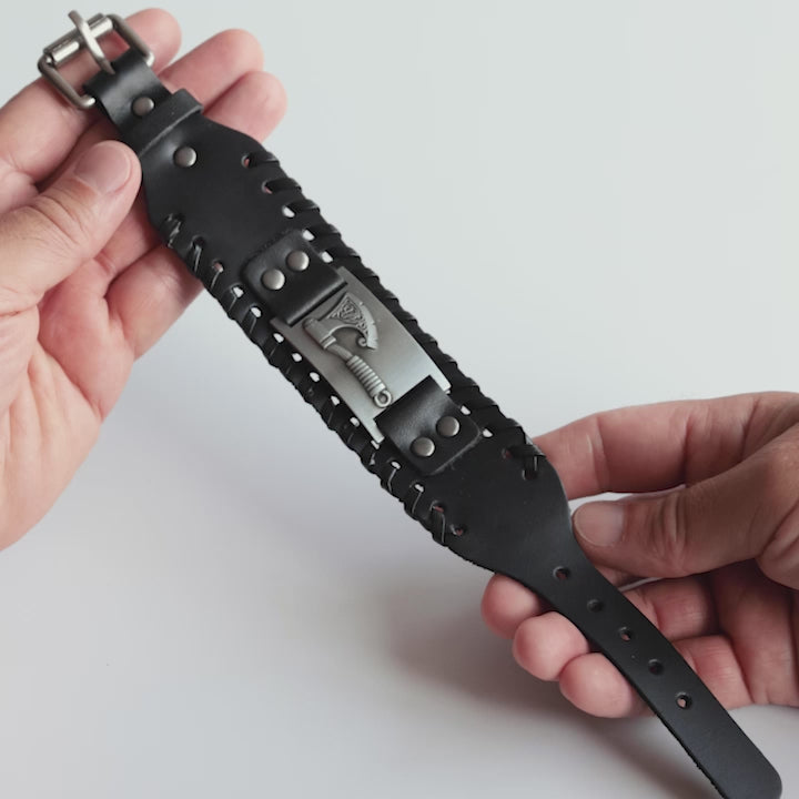 Close-up video of Odin Trinkets black leather Viking bracelet featuring detailed axe symbol, Norse mythology inspired design, and sturdy belt buckle closure for men