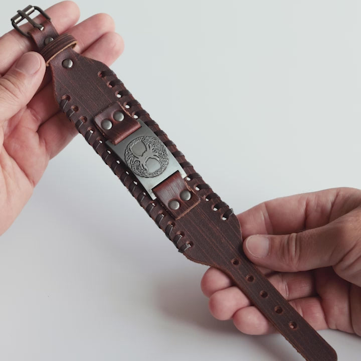 Close-up video of Odin Trinkets close-up video of brown leather Viking bracelet featuring the Yggdrasil tree of life from Norse mythology, highlighted with an adjustable buckle closure for a bold look