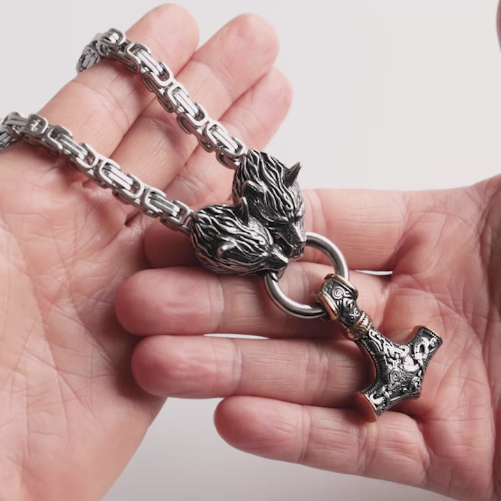 Close-up video of a stainless steel Kings chain with wolf heads featuring a golden mjölnir thors hammer and bold Viking-inspired design. This Norse mythology Necklace symbolizes strength and ferocity, captured in detail to highlight its craftsmanship – a statement piece from Odin Trinkets.