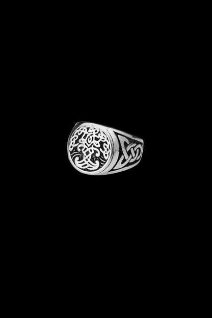 A stainless steel Yggdrasil ring showcasing the Tree of Life with detailed Celtic knotwork on the sides. The minimalist black background emphasizes the intricate Norse-inspired design. Available at Odin Trinkets.